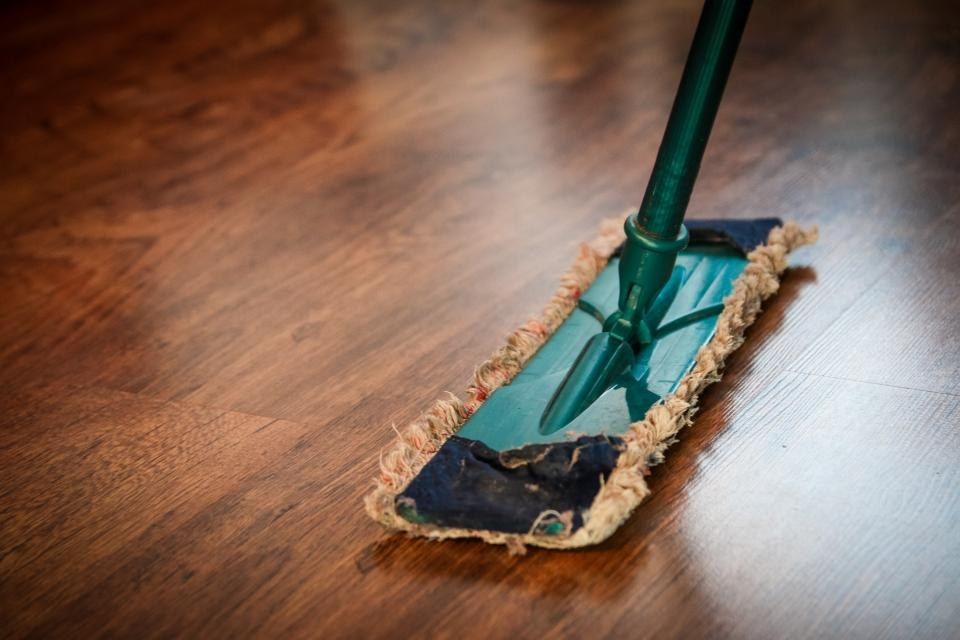 Trapero limpiando un piso de madera